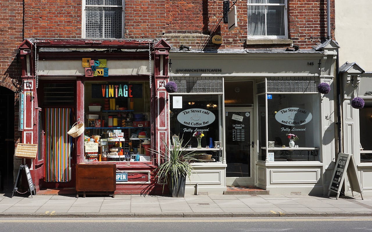 about-us-01 Vintage shop and cafe in Norwich showcasing eclectic storefronts and vibrant signage.