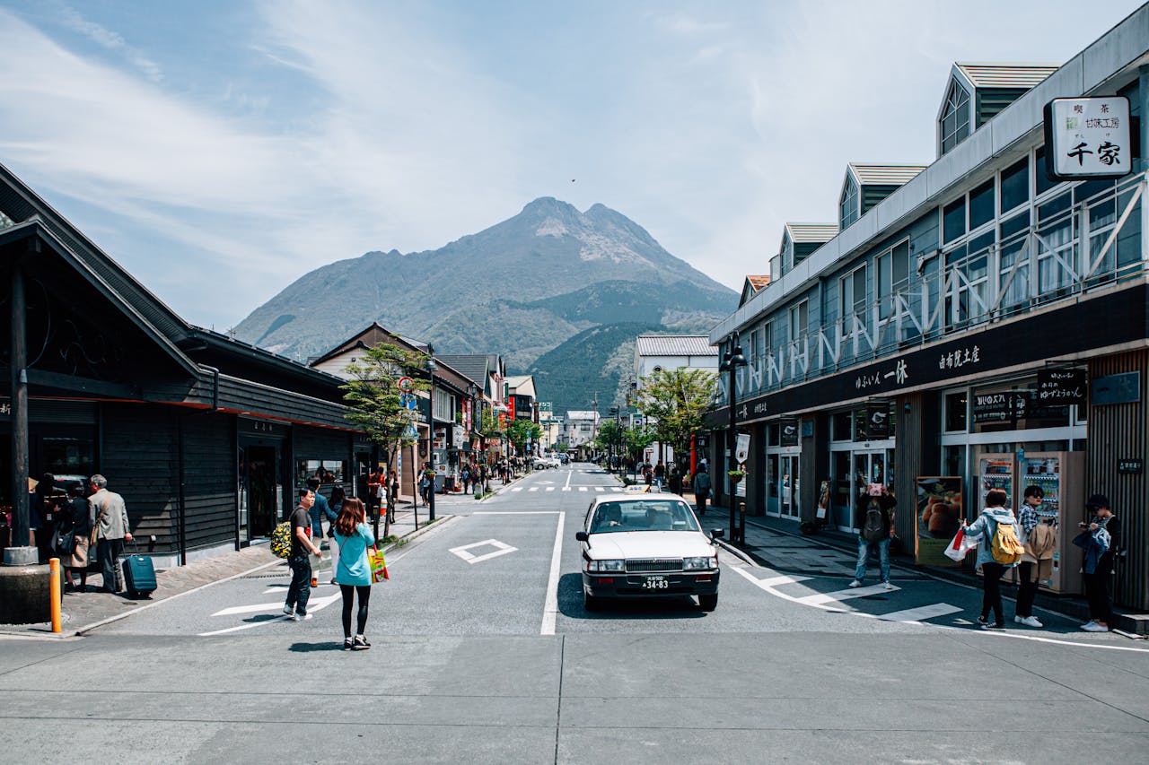 services-04 Dynamic town street scene with shopping and mountain backdrop, showcasing urban life.